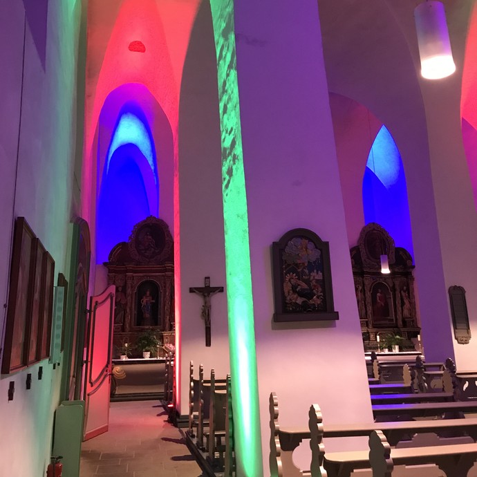 Grün, rot und blau erstrahltes Seitenschiff der Pfarrkirche St. Nikolaus in Arnsberg Rumbeck. © Thomas Niemand.