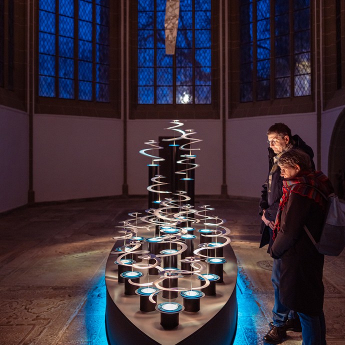Zwei Besucher:innen betrachten eine Lichtinstallation. (vergrößerte Bildansicht wird geöffnet)