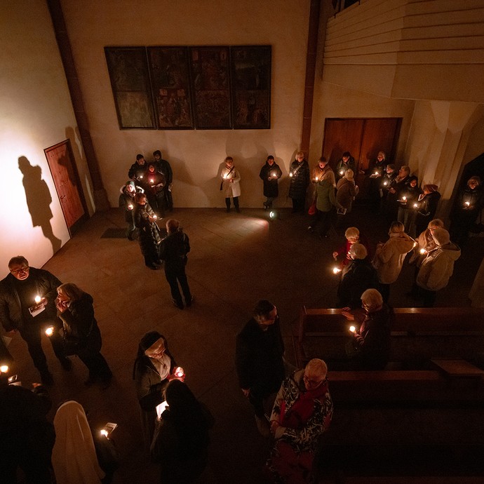 Verstreute Gruppe mit Menschen, die Kerzen in der Hand halten. (vergrößerte Bildansicht wird geöffnet)