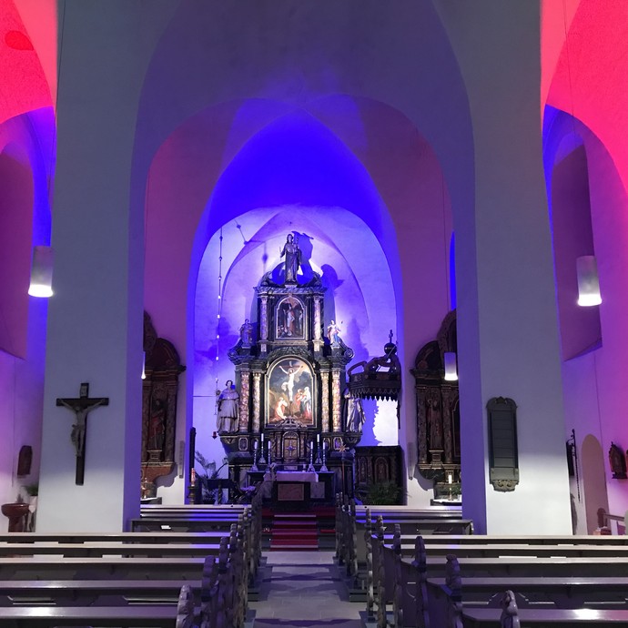 Blick aus dem Langhaus der Stiftskirche St. Nikolaus auf den festlich illuminierten Altarraum